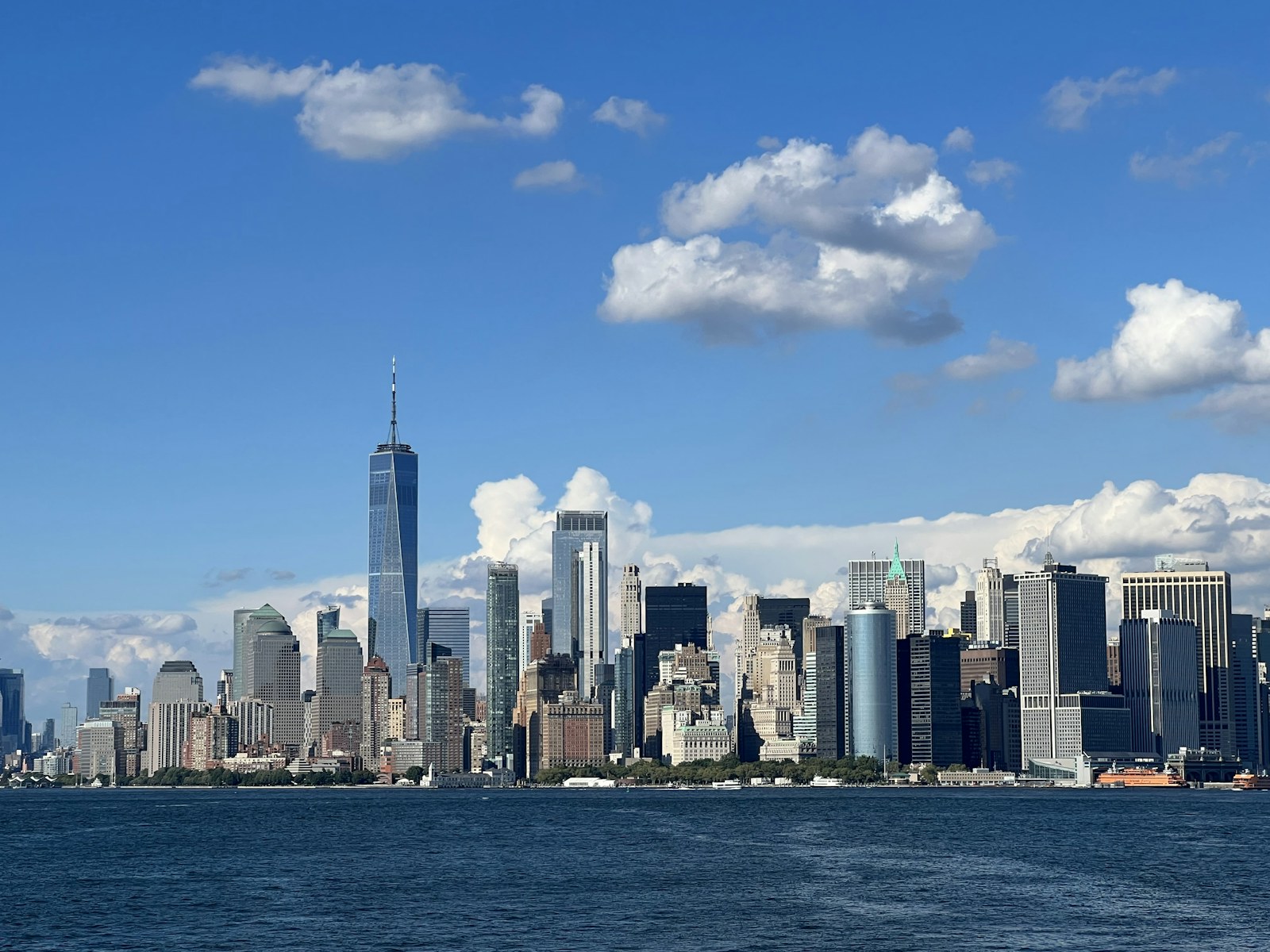 Lower Manhattan skyline with One World Trade Center rising above the harbor.