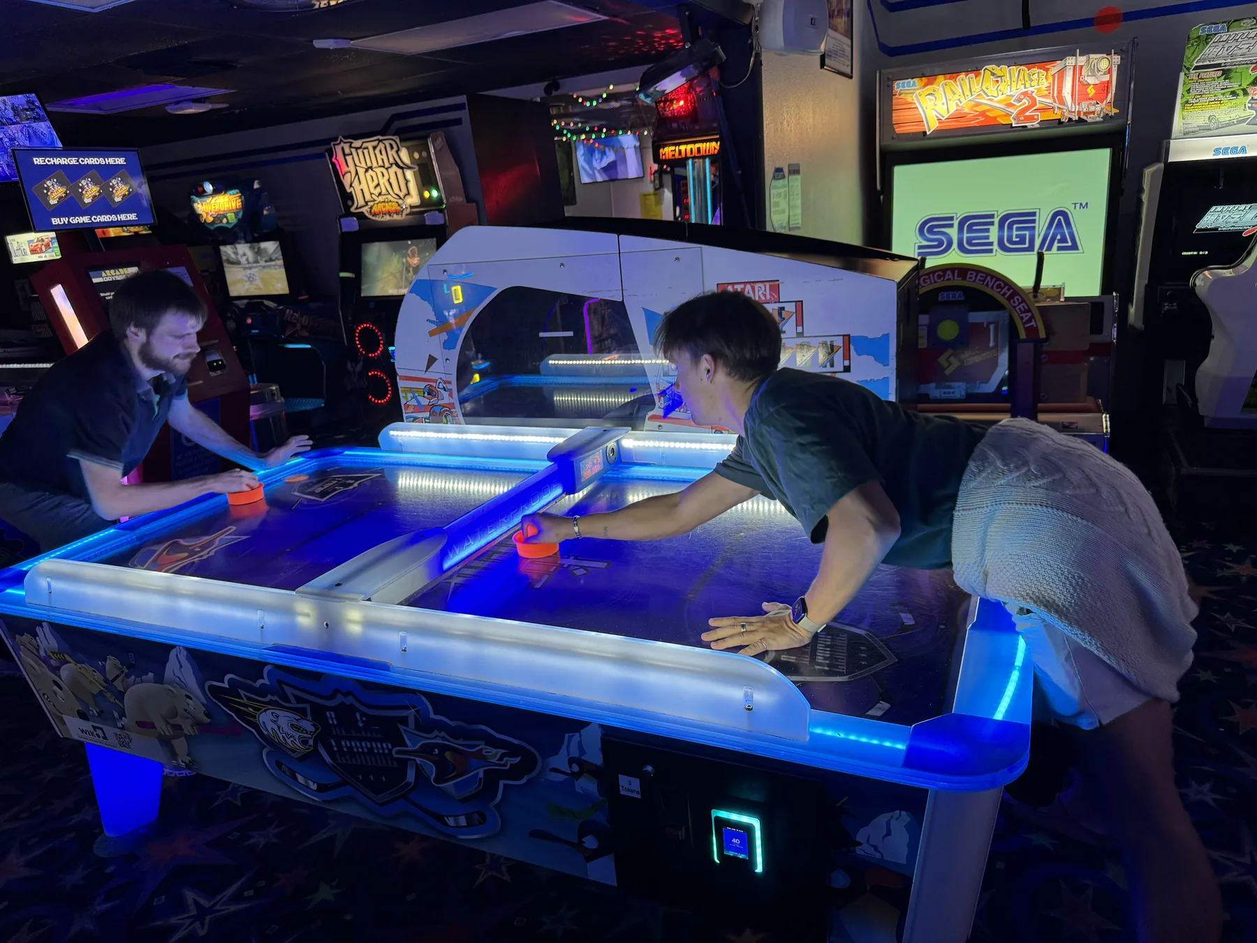 Teammates playing air hockey during the Miami offsite.