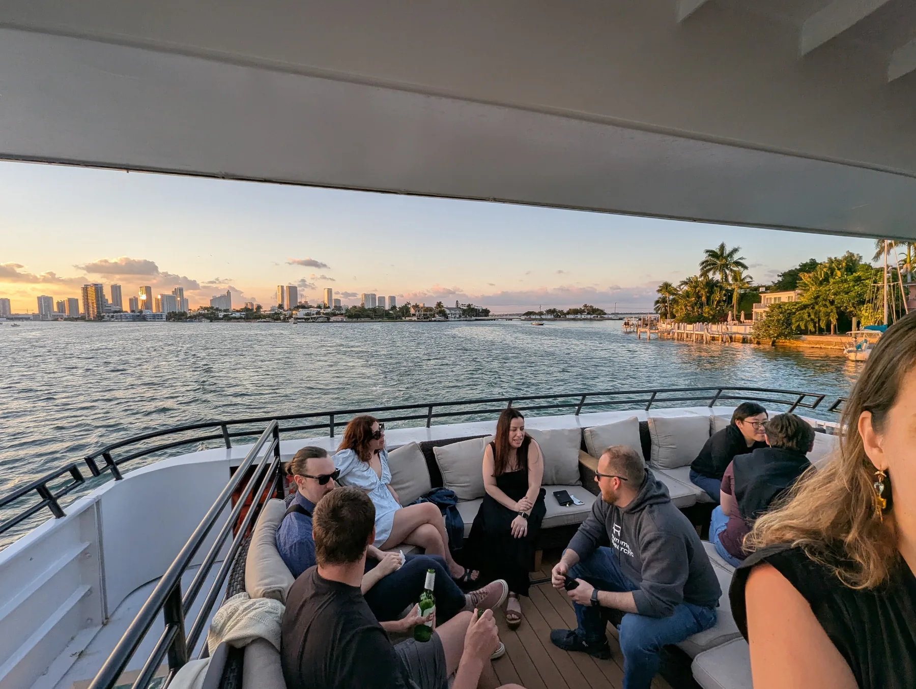 Teammates gathered on a boat with the Miami skyline across the water.